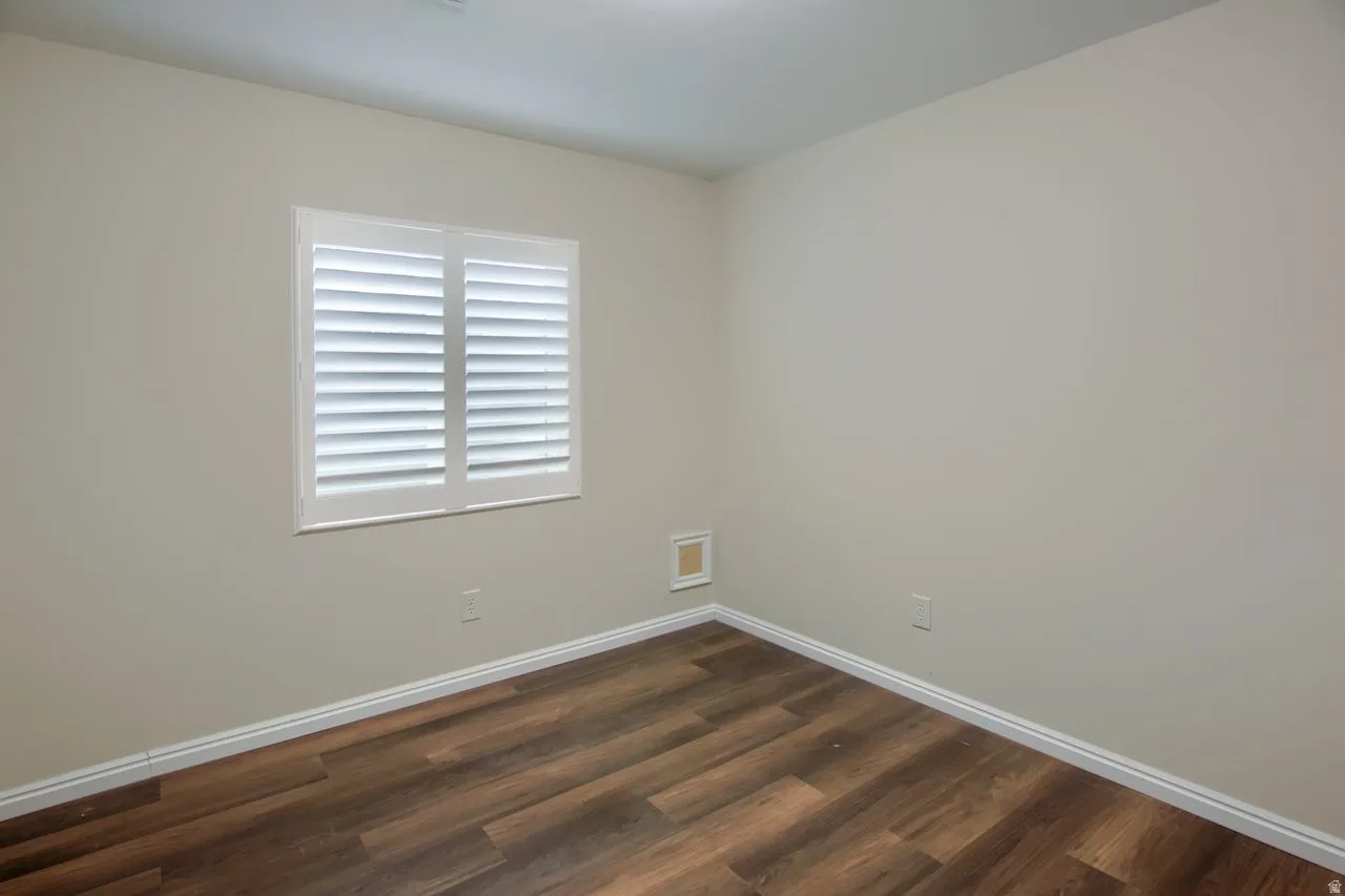 Unfurnished room featuring dark wood-style floors