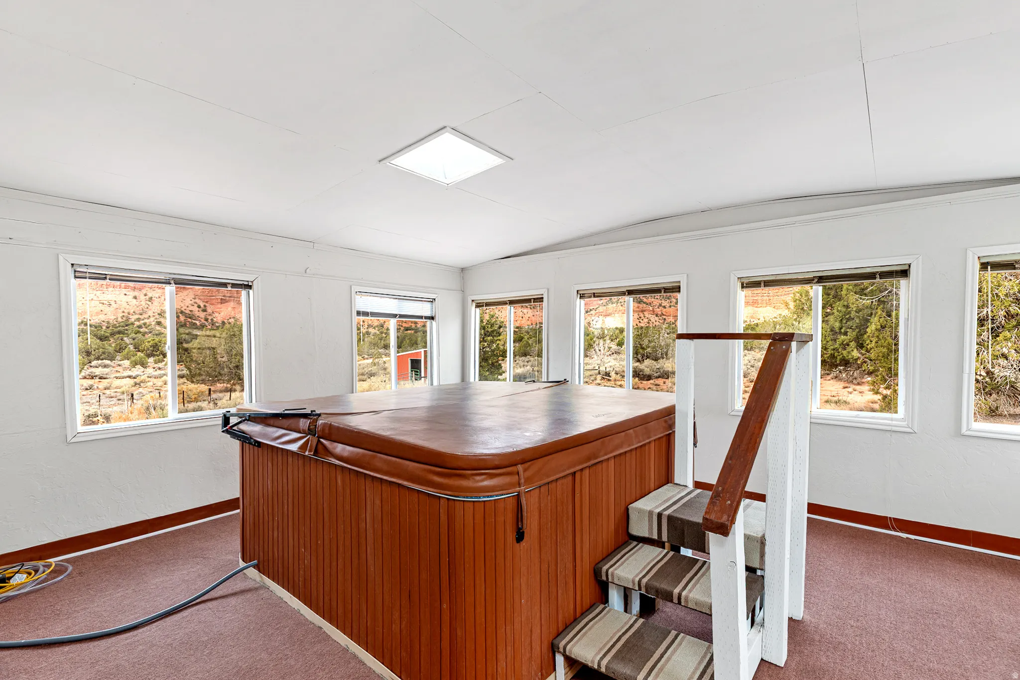 Office area featuring plenty of natural light, lofted ceiling, and dark colored carpet