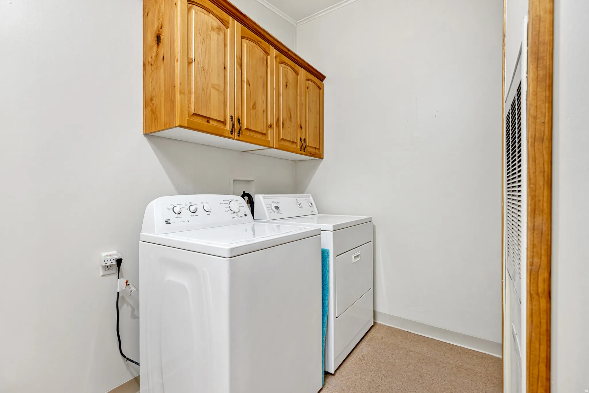 Laundry area with cabinet space, washing machine and clothes dryer, and a heating unit