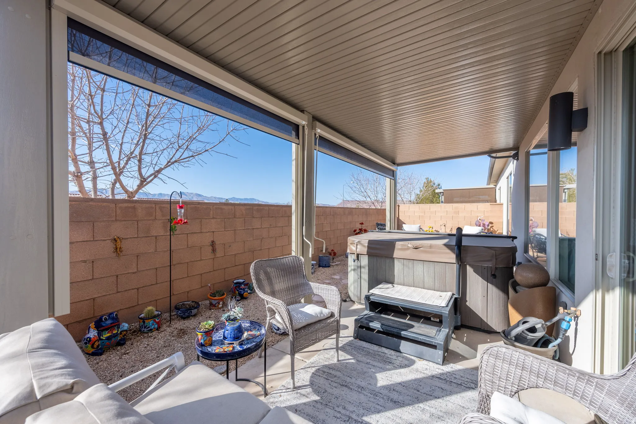 Fenced backyard with a hot tub, a patio, a mountain view, and an outdoor hangout area