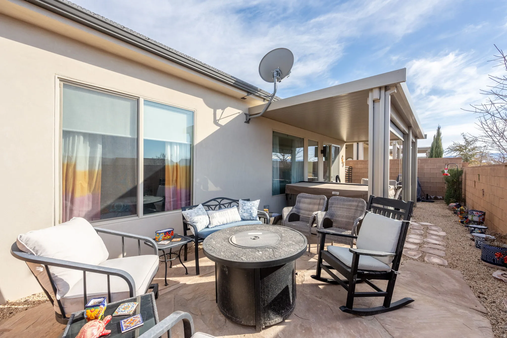 Fenced backyard featuring a patio area, an outdoor living space with a fire pit, and a hot tub
