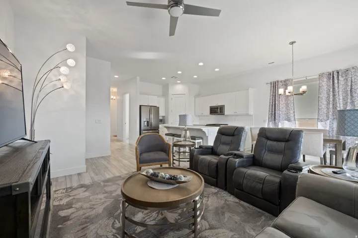 Living room with a chandelier, light wood-style floors, recessed lighting, and ceiling fan