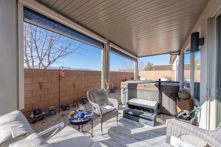 Fenced backyard with a hot tub, a patio, a mountain view, and an outdoor hangout area