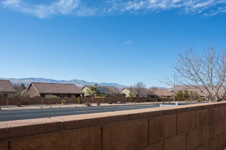 View of asphalt road featuring a mountain view and sidewalks