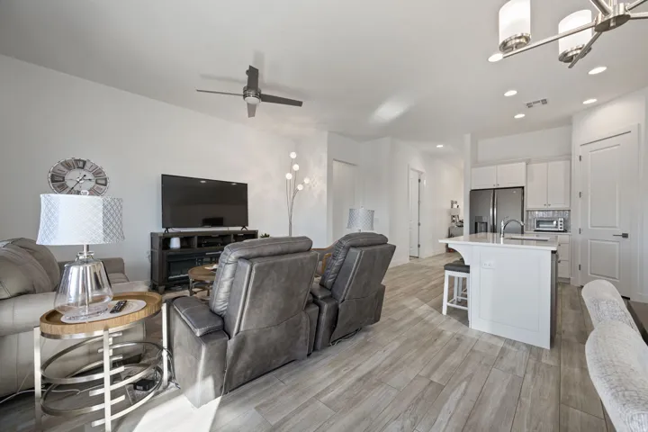 Living room with recessed lighting, light wood-style flooring, a ceiling fan, and a chandelier