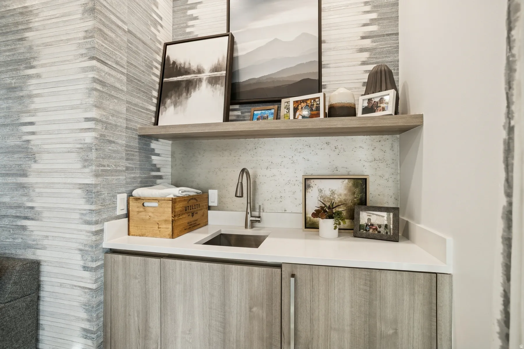 Bar with open shelves, modern cabinets, light brown cabinets, and light stone counters