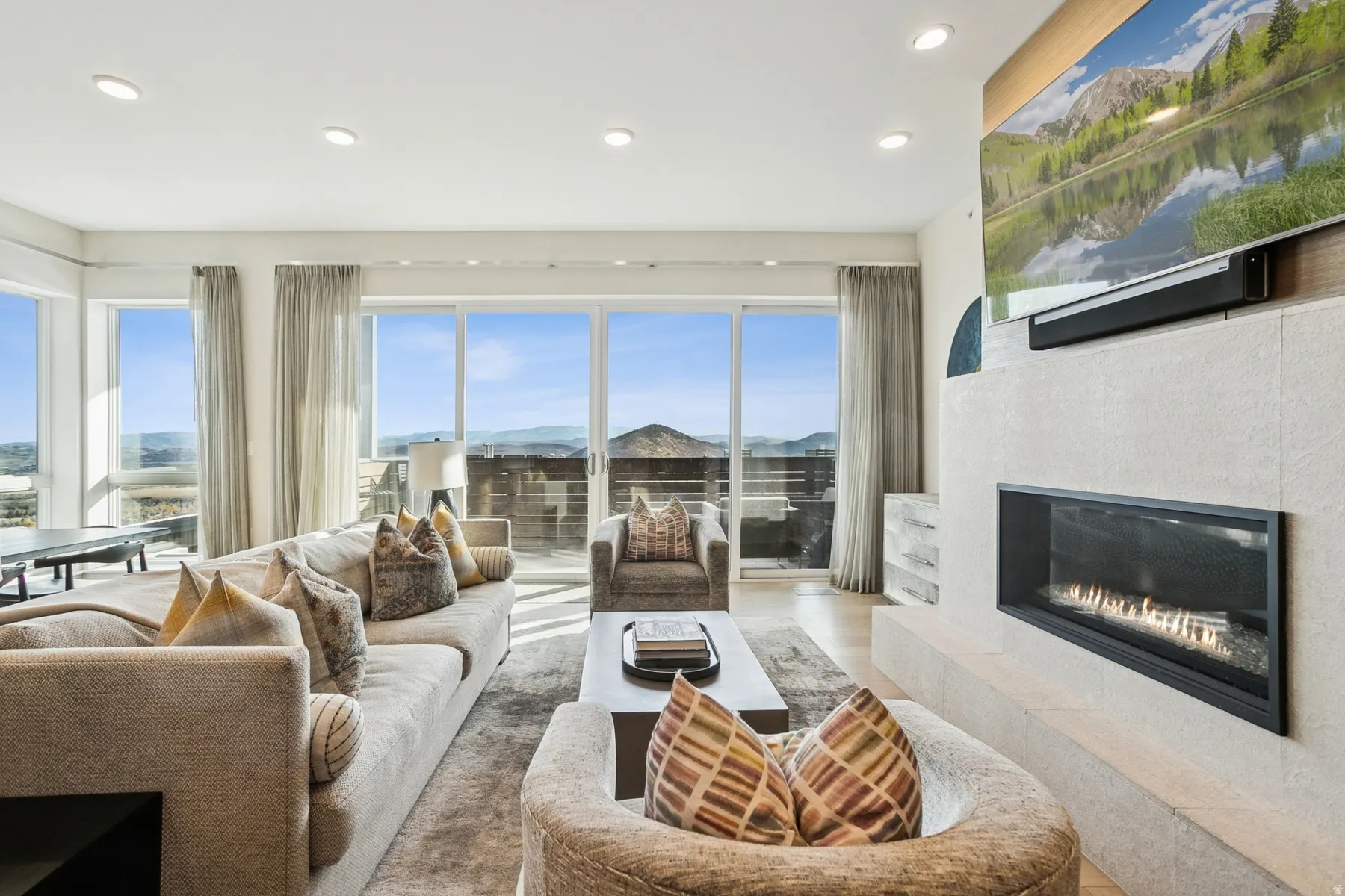 Living area with a tiled fireplace, recessed lighting, and wood finished floors