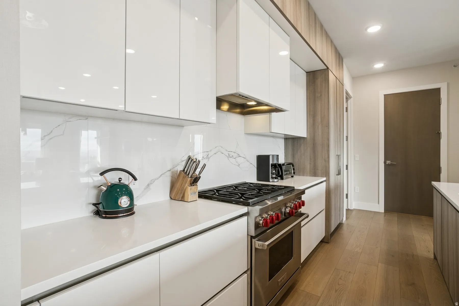 Kitchen with white cabinets, premium stove, modern cabinets, dark wood-style floors, and recessed lighting