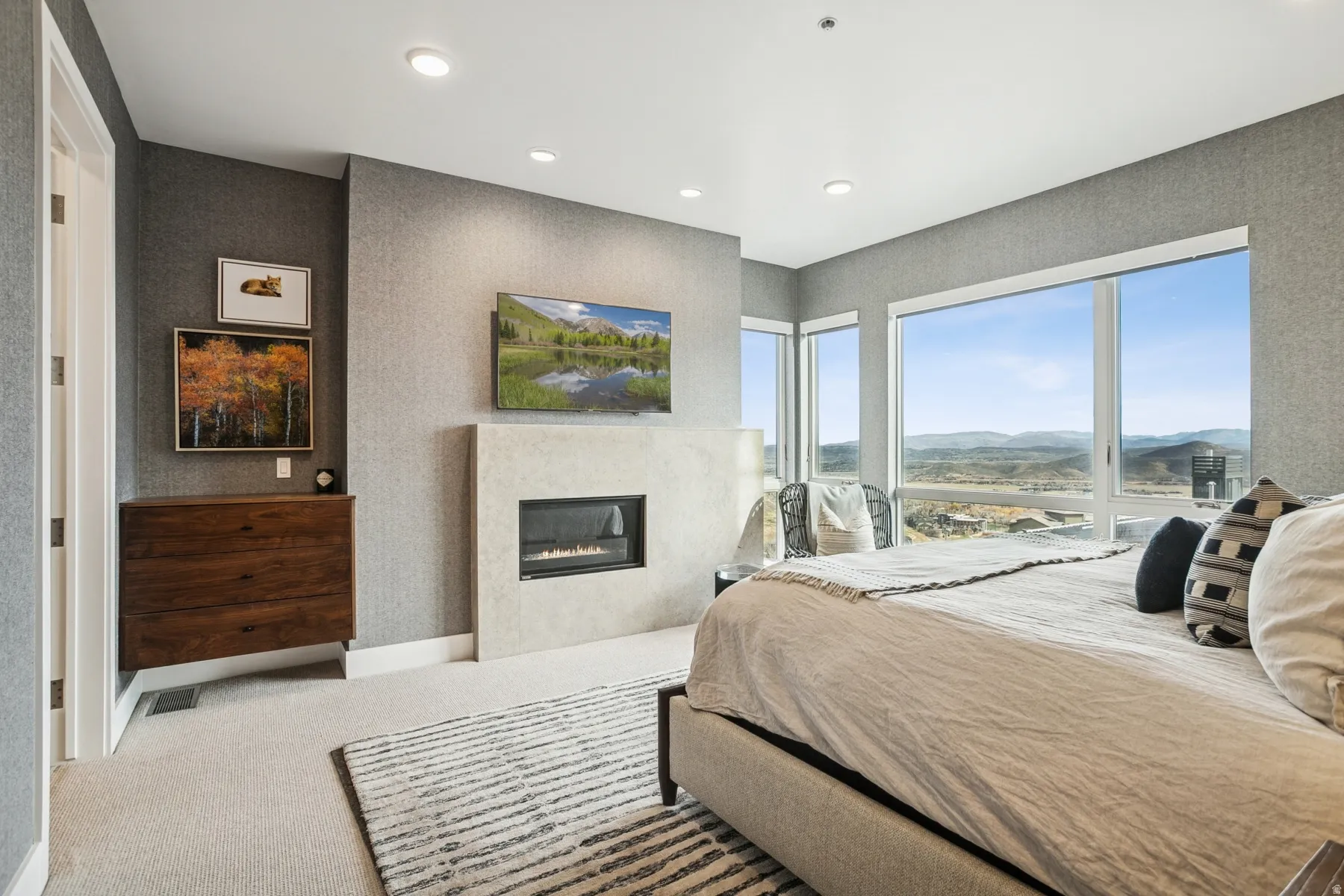 Carpeted bedroom featuring a glass covered fireplace and recessed lighting
