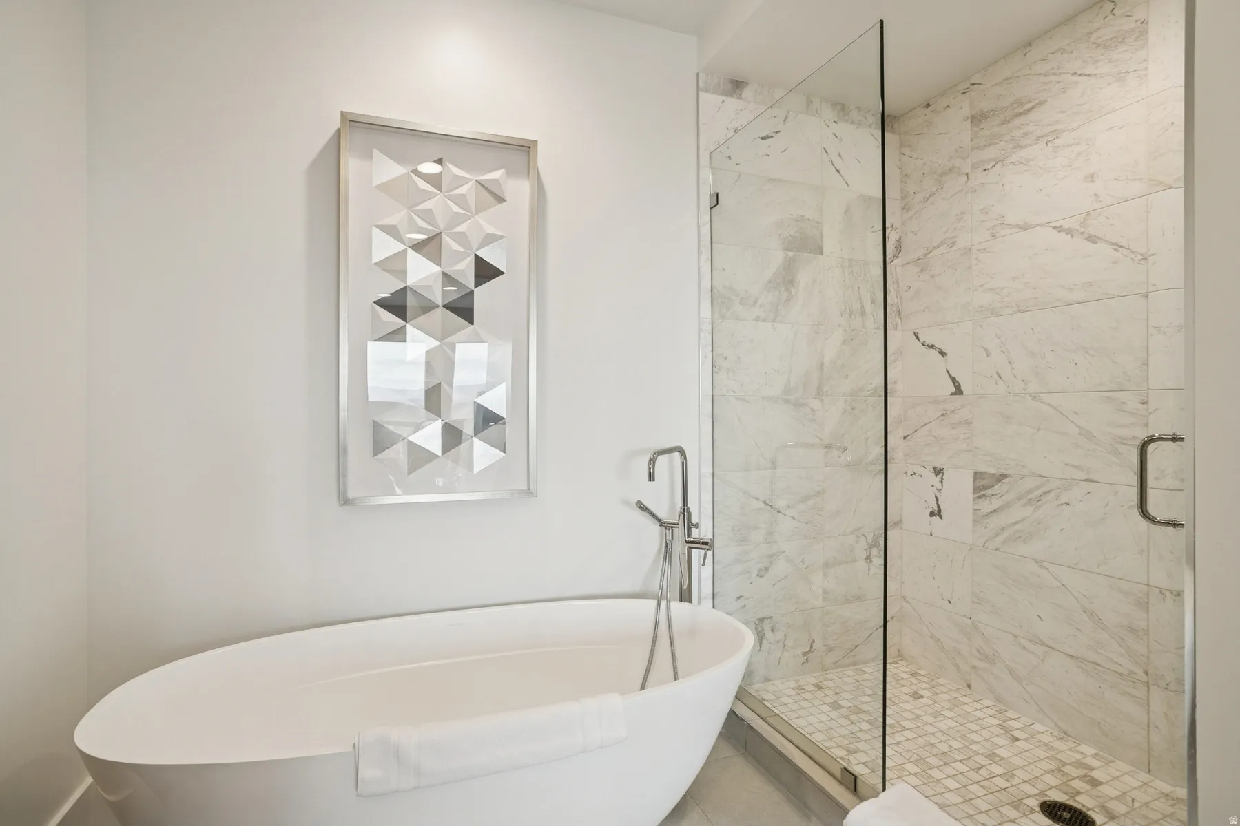 Full bath featuring a freestanding tub and a shower stall