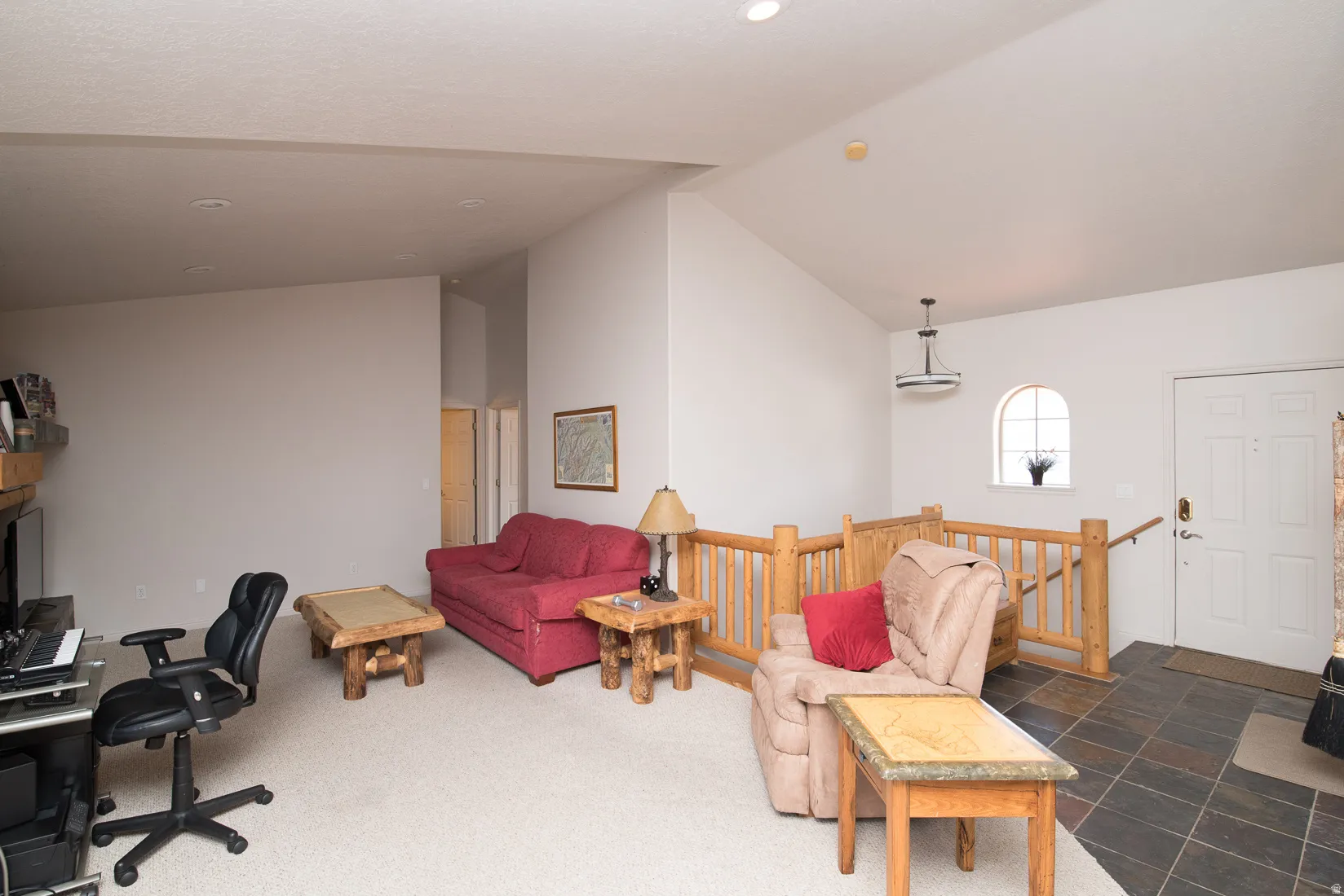 Office space with high vaulted ceiling and dark colored carpet