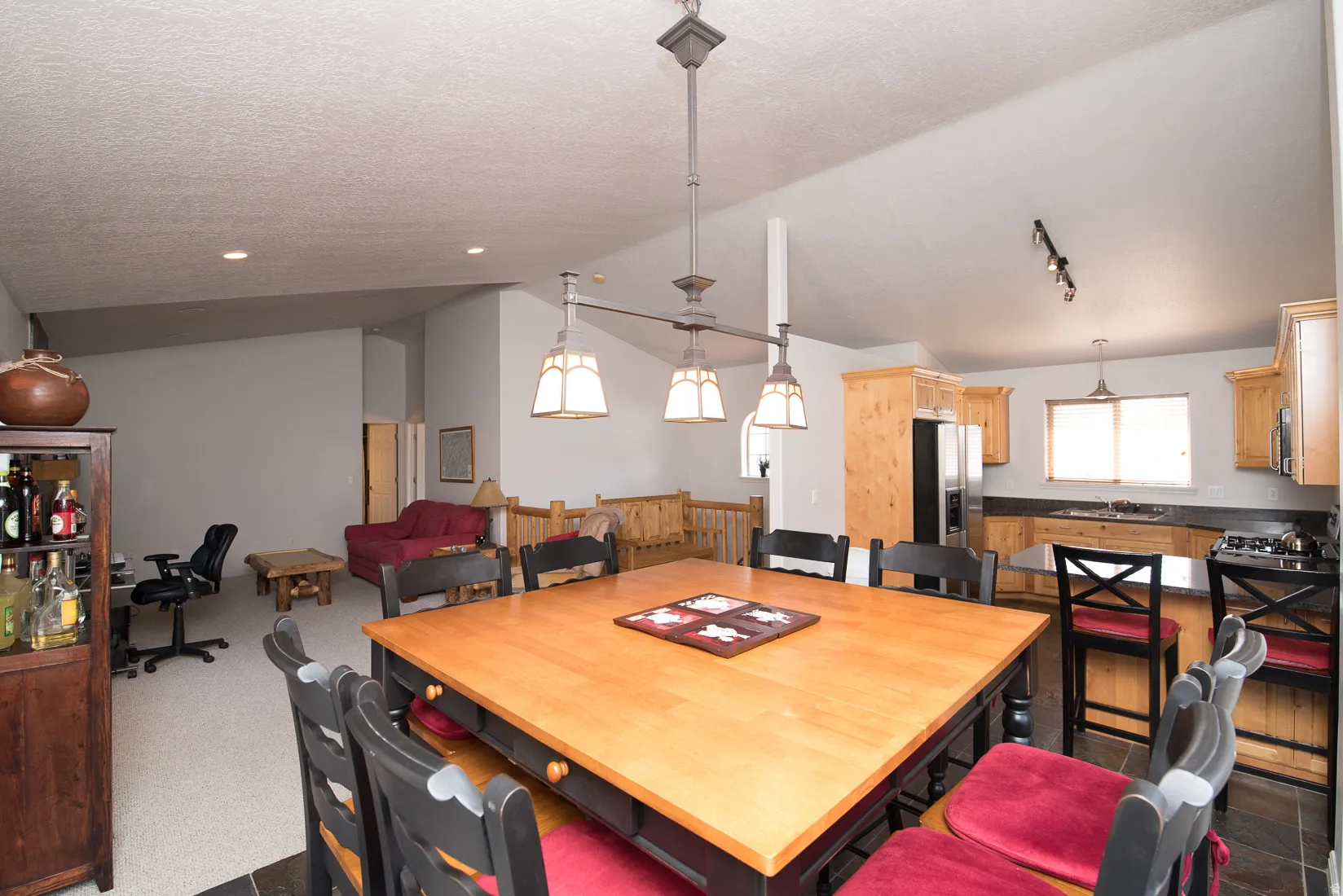 Dining area featuring lofted ceiling, a textured ceiling, and dark carpet