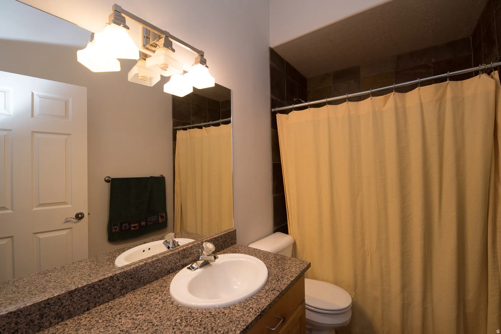 Full bathroom featuring curtained shower and vanity
