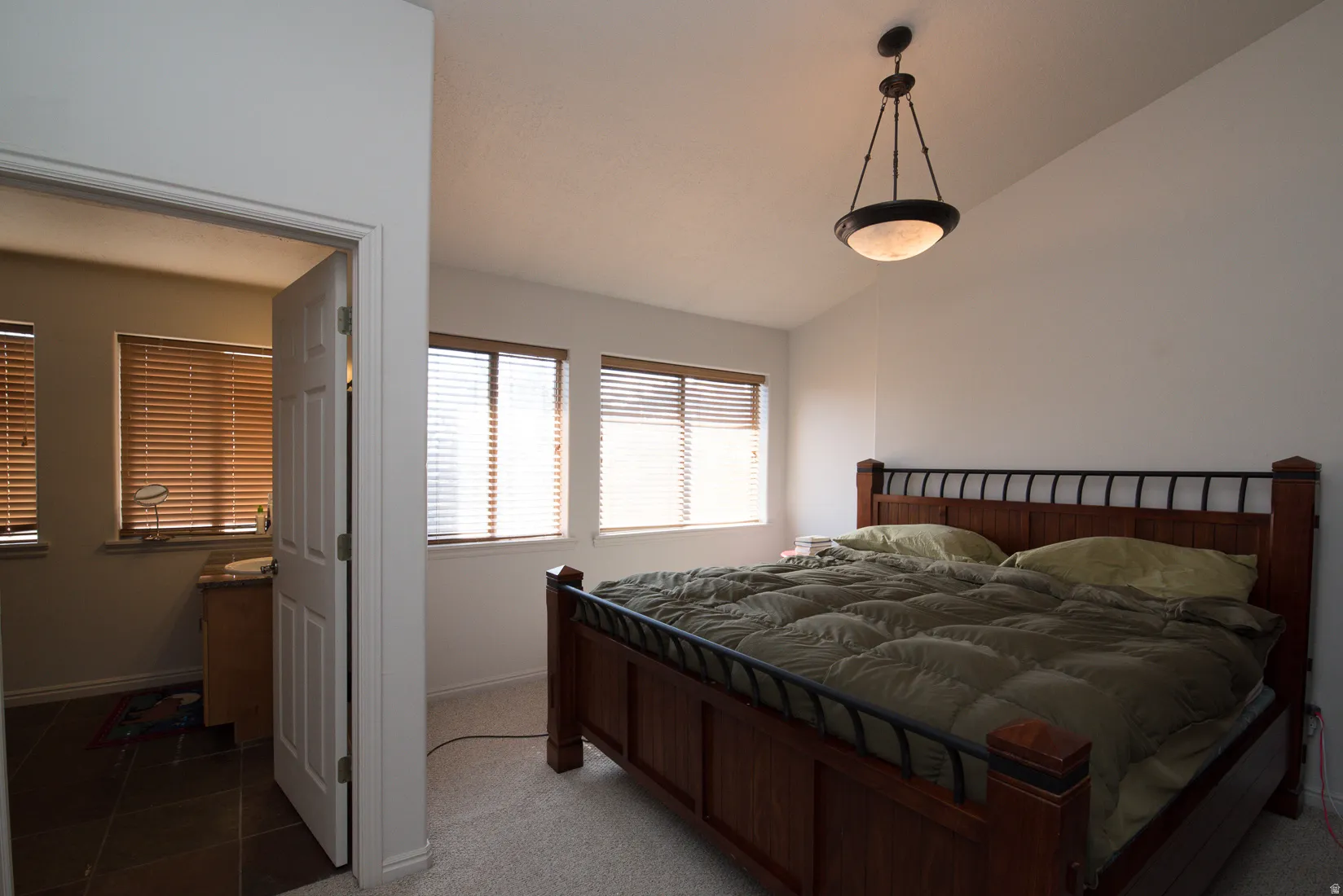 Bedroom with lofted ceiling, carpet floors, and tile patterned flooring