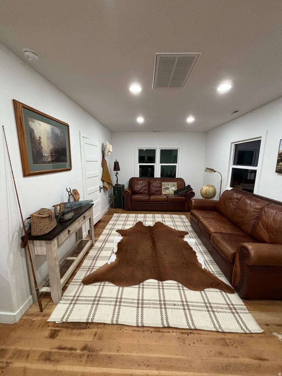 Living area with light wood-type flooring and recessed lighting