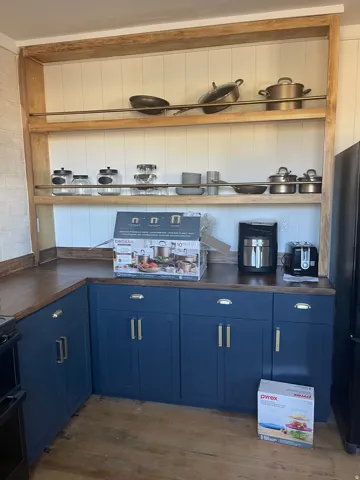 Bar area featuring blue cabinets, open shelves, black range, dark wood-type flooring, and white cabinets