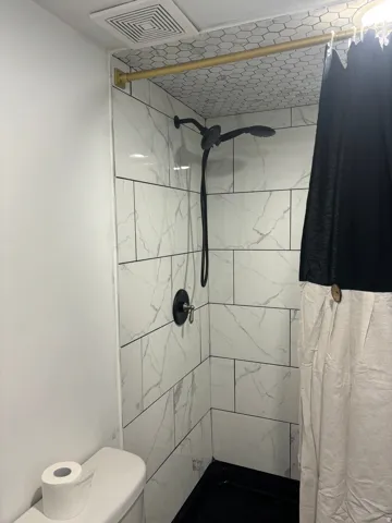 Full bathroom featuring a shower stall