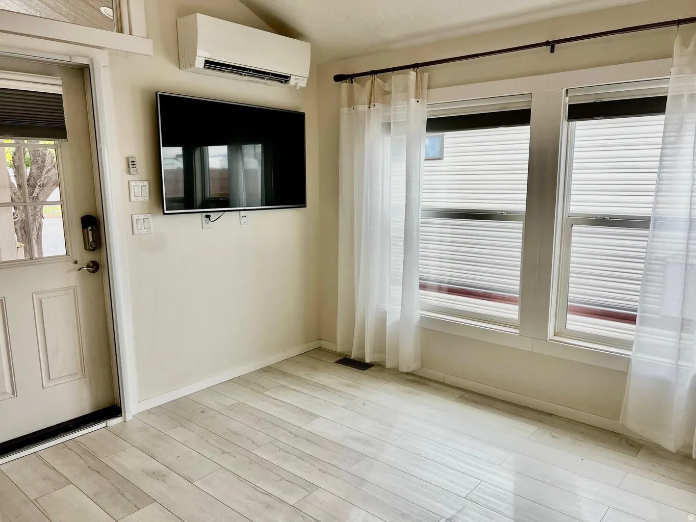 Entryway with a wall mounted air conditioner, plenty of natural light, and light wood-type flooring