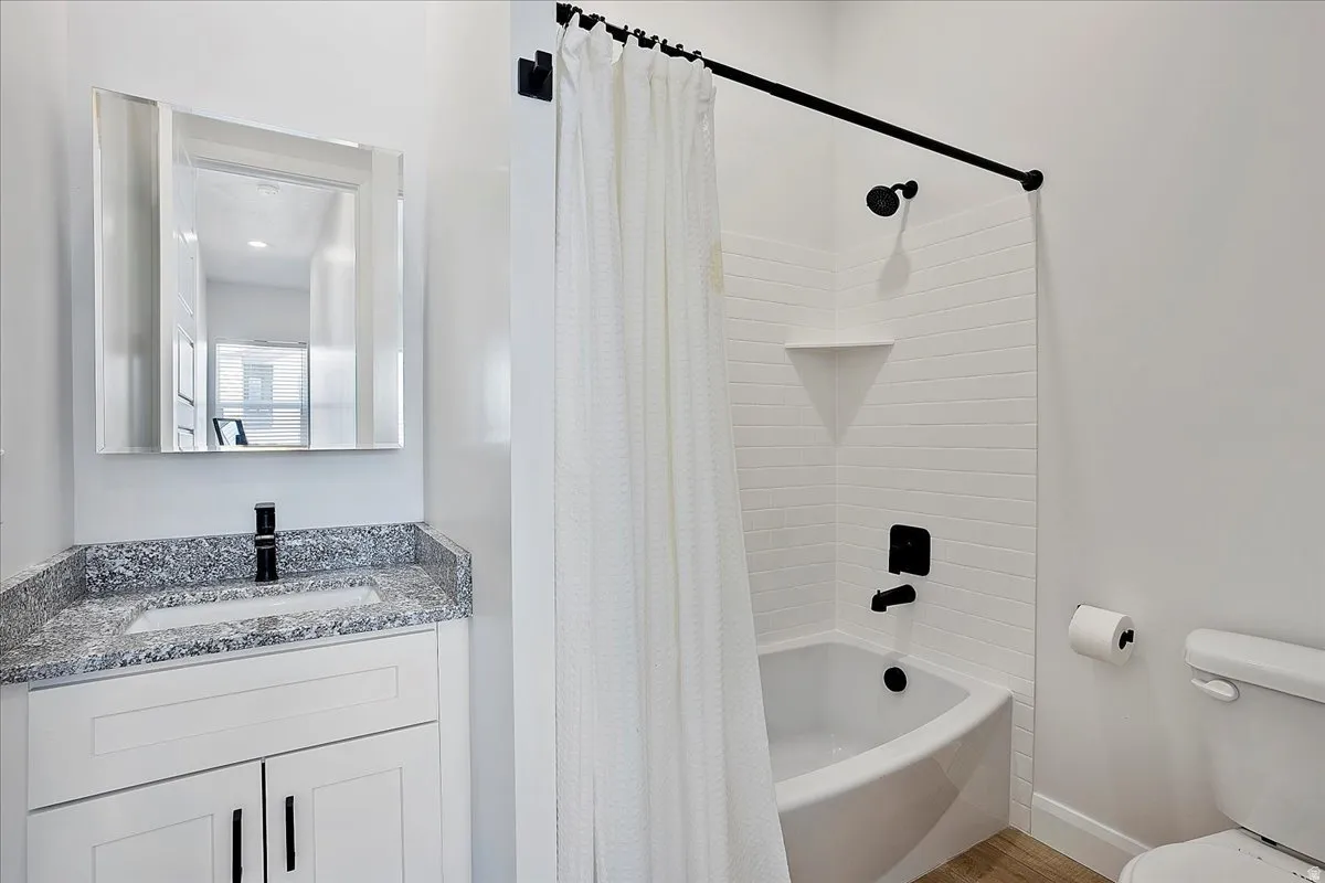 Bathroom featuring shower / bath combo with shower curtain and vanity