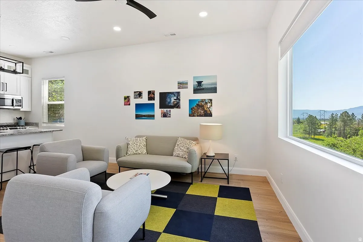 Living area featuring a ceiling fan, light wood-style floors, and recessed lighting