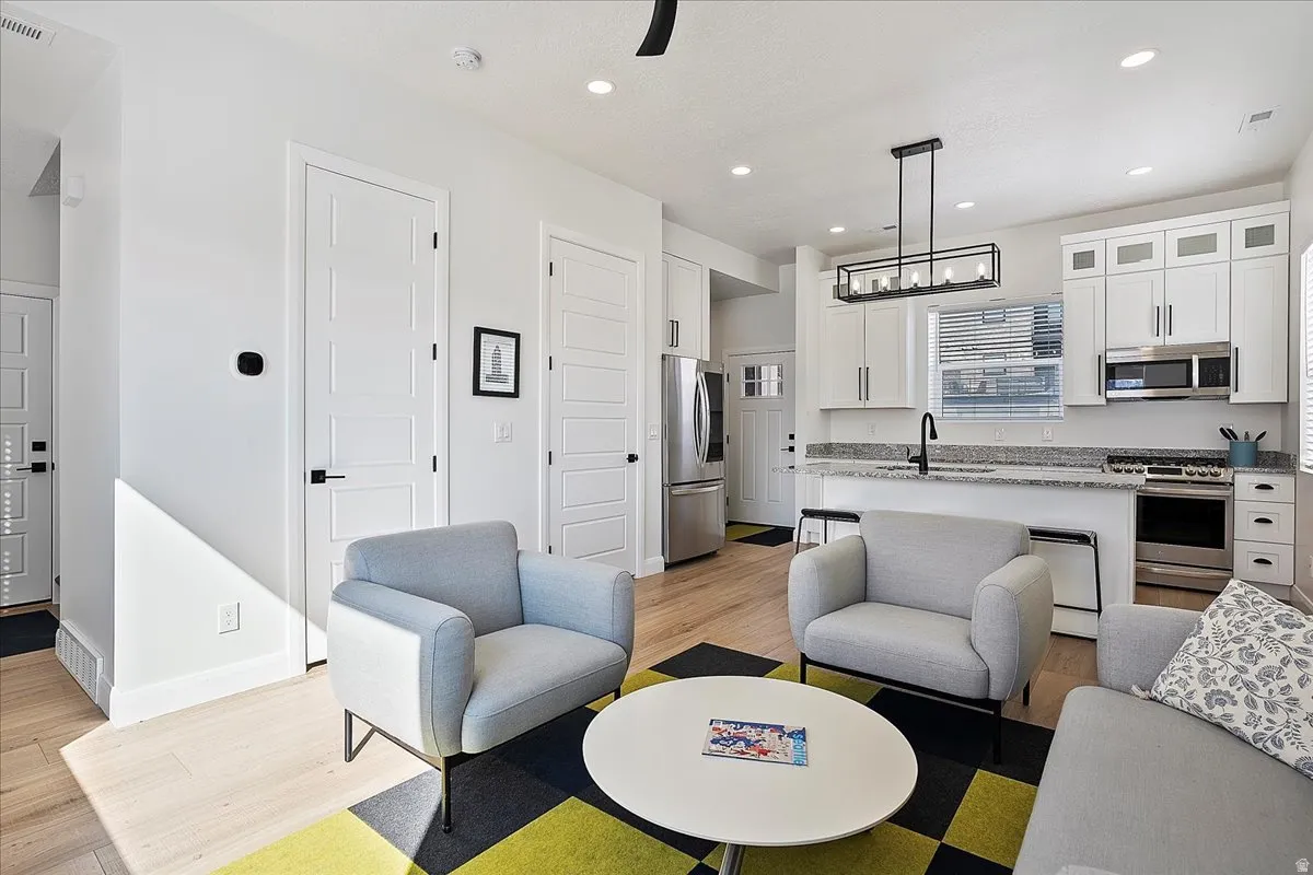 Living area with light wood-type flooring, recessed lighting, and a chandelier