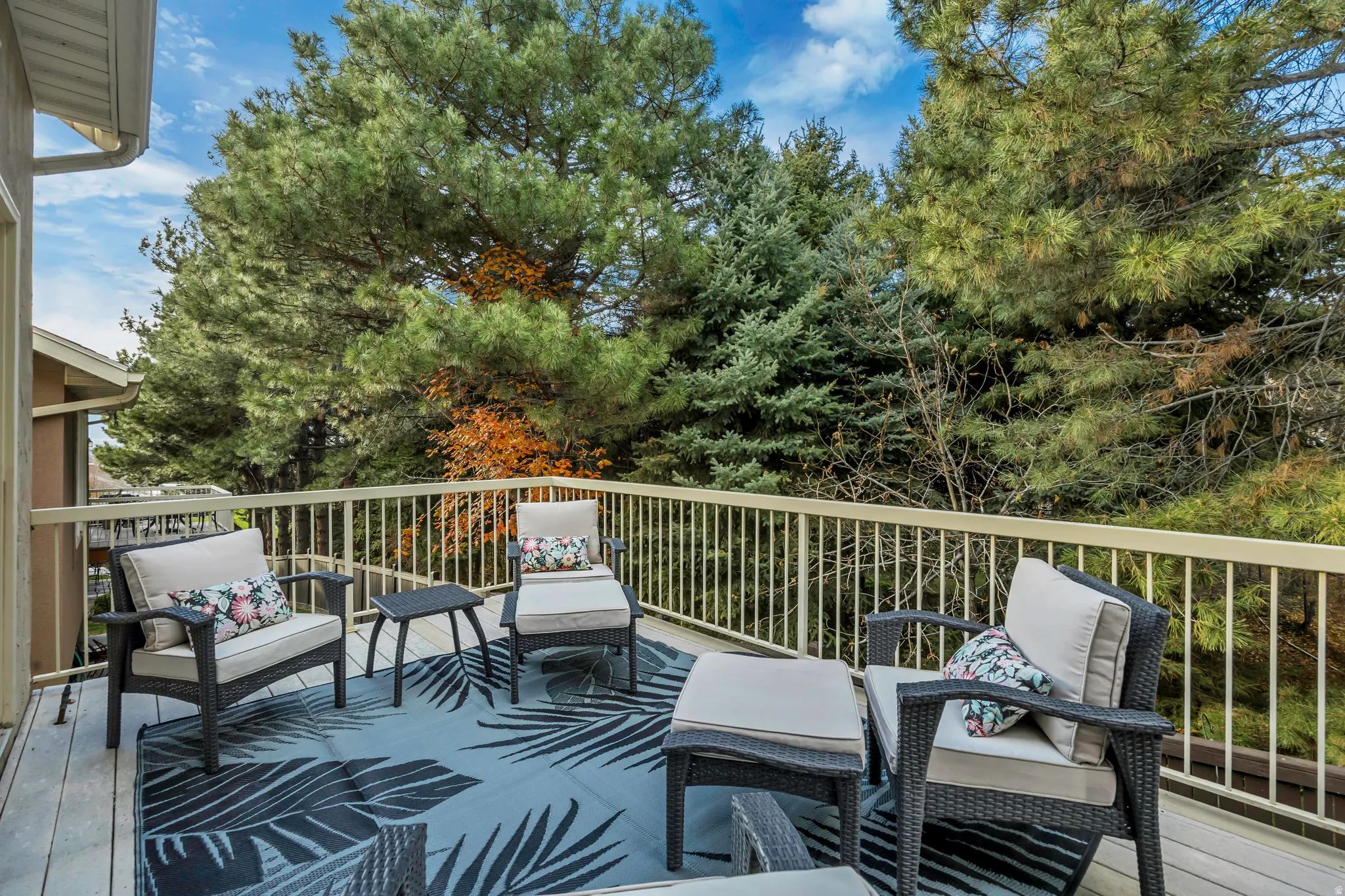 Deck with outdoor lounge area and view of wooded area