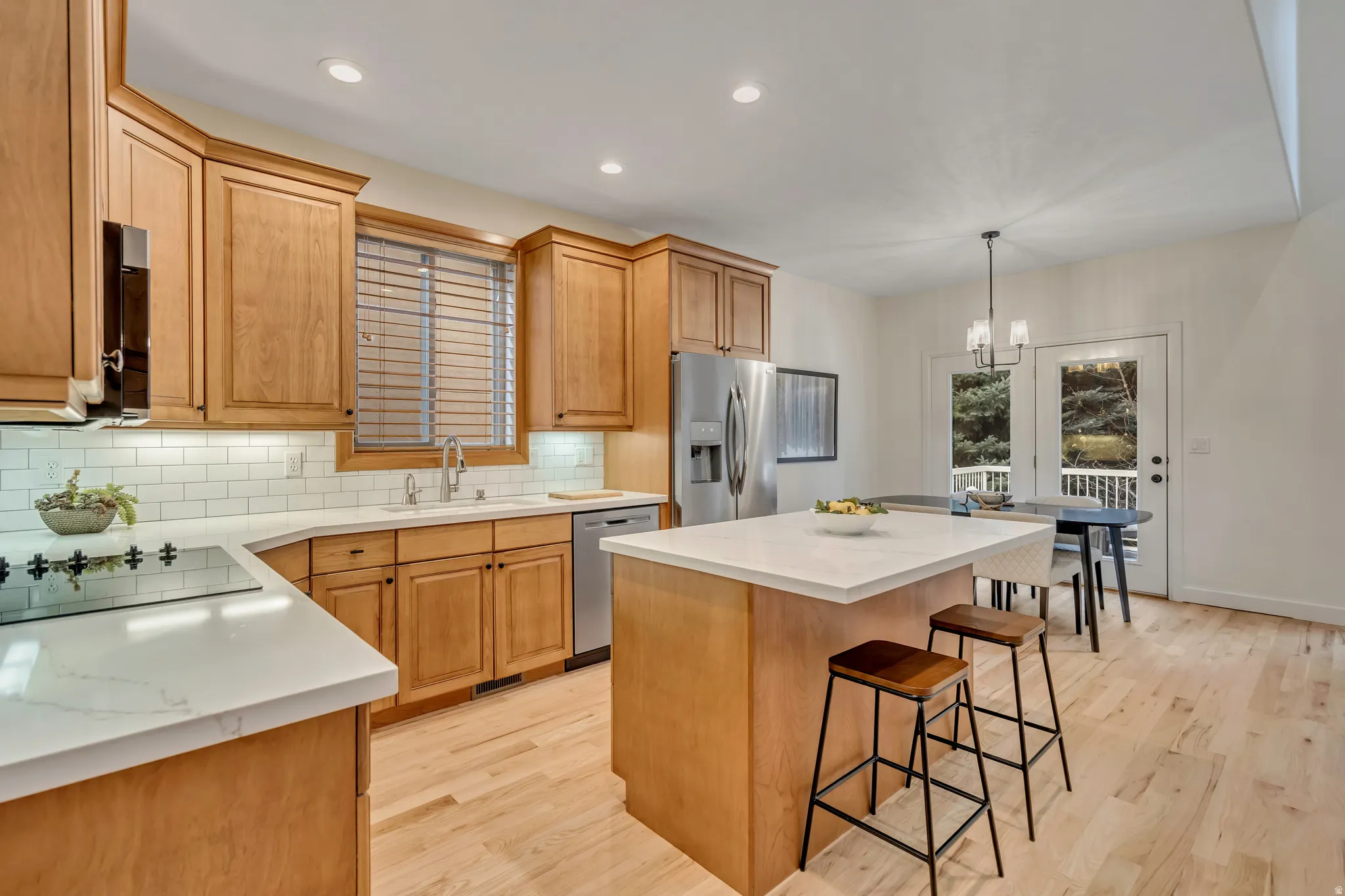 Kitchen featuring a center island, light wood-style flooring, appliances with stainless steel finishes, recessed lighting, and decorative backsplash