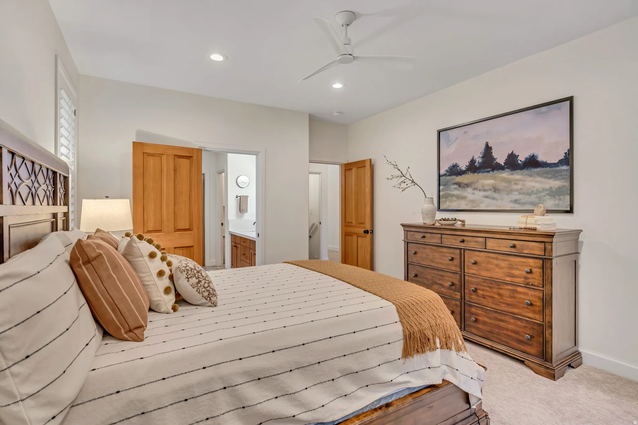 Main Level Primary Bedroom featuring recessed lighting, carpet flooring, ceiling fan, and ensuite bath