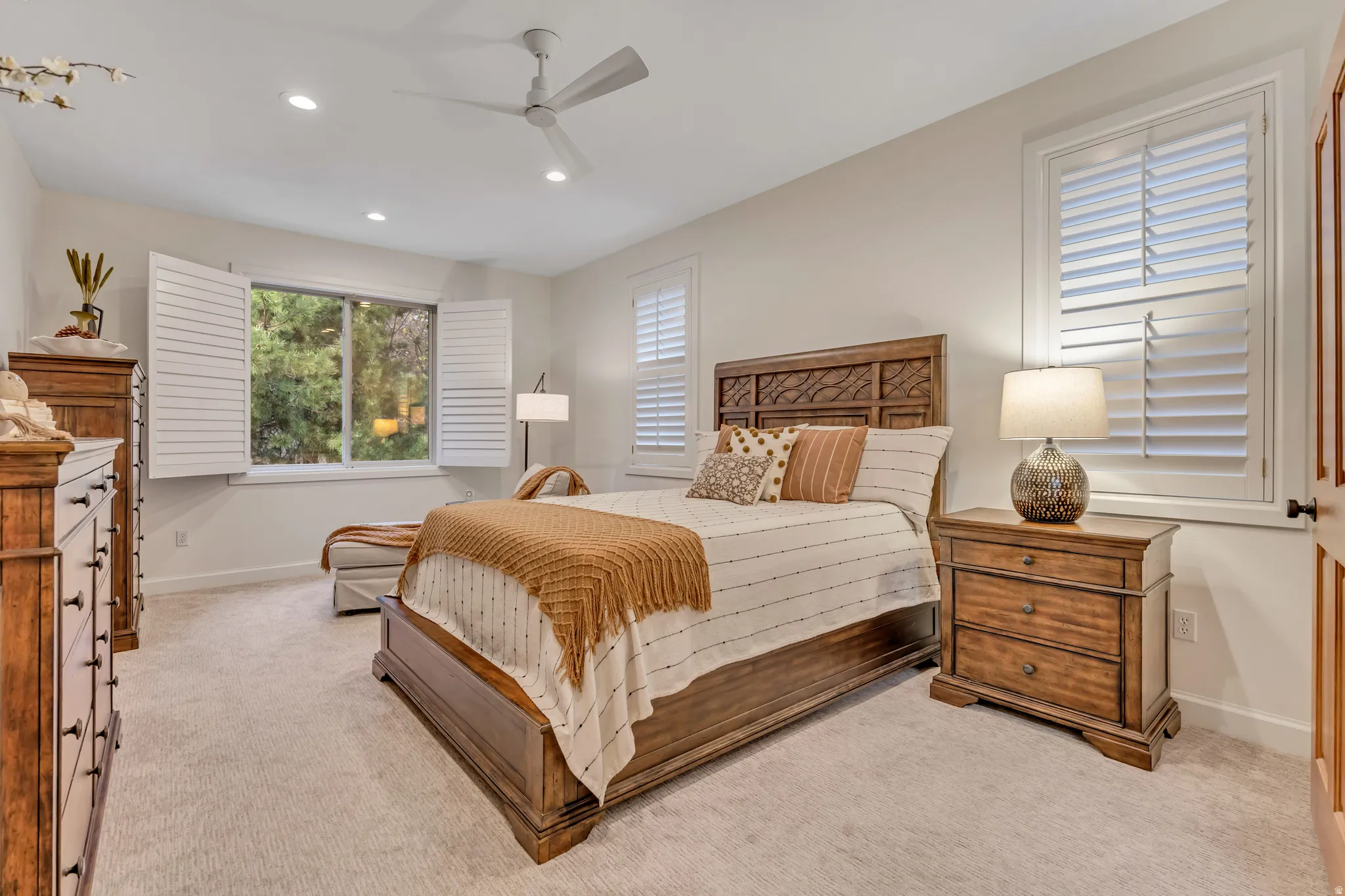 Main Level Primary Bedroom featuring a ceiling fan, recessed lighting, and light carpet