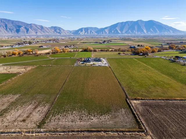 Aerial view of sparsely populated area with a mountain backdrop and extensive farmland