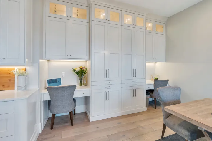 Office with built in desk and light wood-style flooring