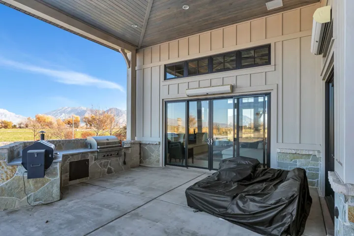 View of patio / terrace featuring a mountain view, exterior kitchen, and a wall mounted air conditioner