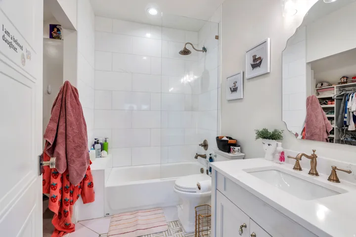 Bathroom featuring vanity, bathing tub / shower combination, light tile patterned floors, and a spacious closet