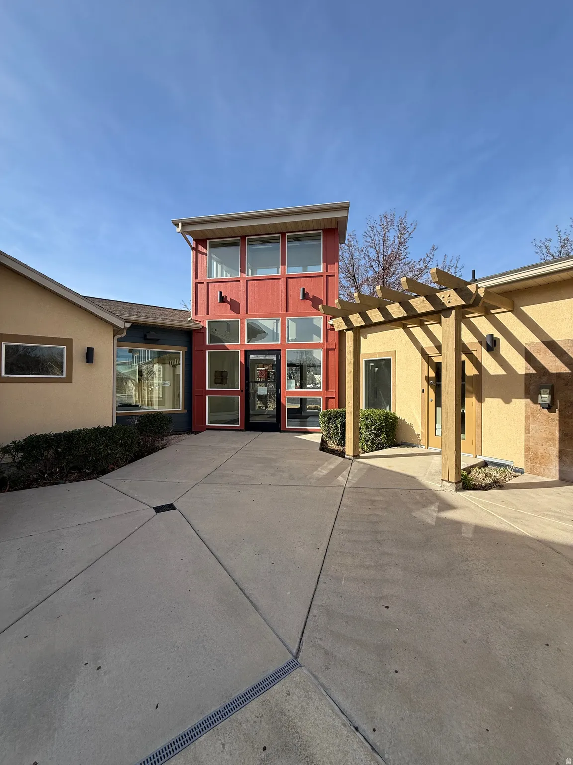 View of front of house featuring stucco siding and a pergola