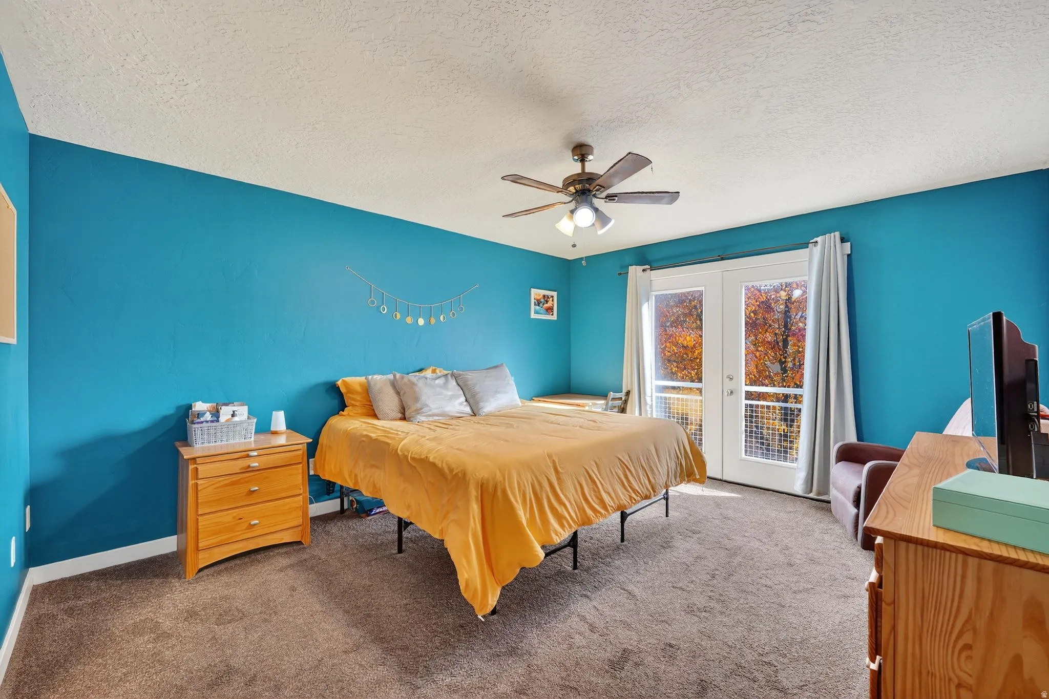Bedroom featuring carpet, access to exterior, a textured ceiling, ceiling fan, and french doors