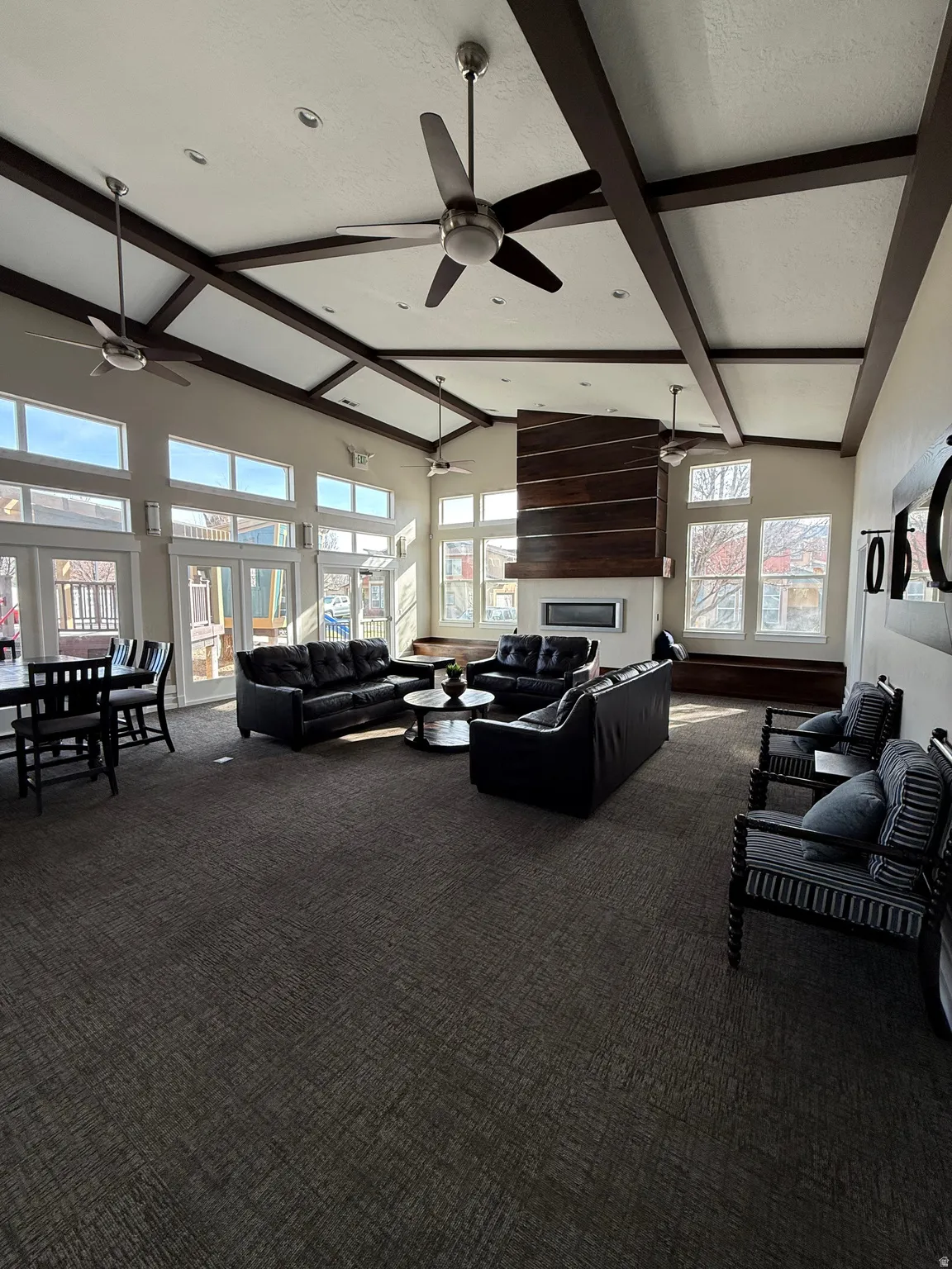 Living room featuring dark colored carpet, lofted ceiling, and ceiling fan