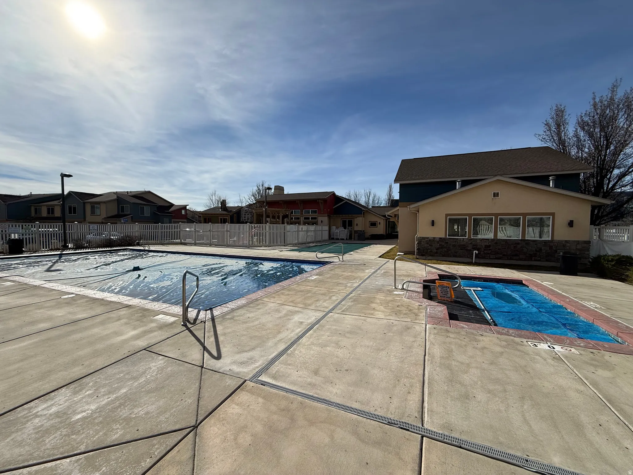 Community pool with a patio area and a residential view