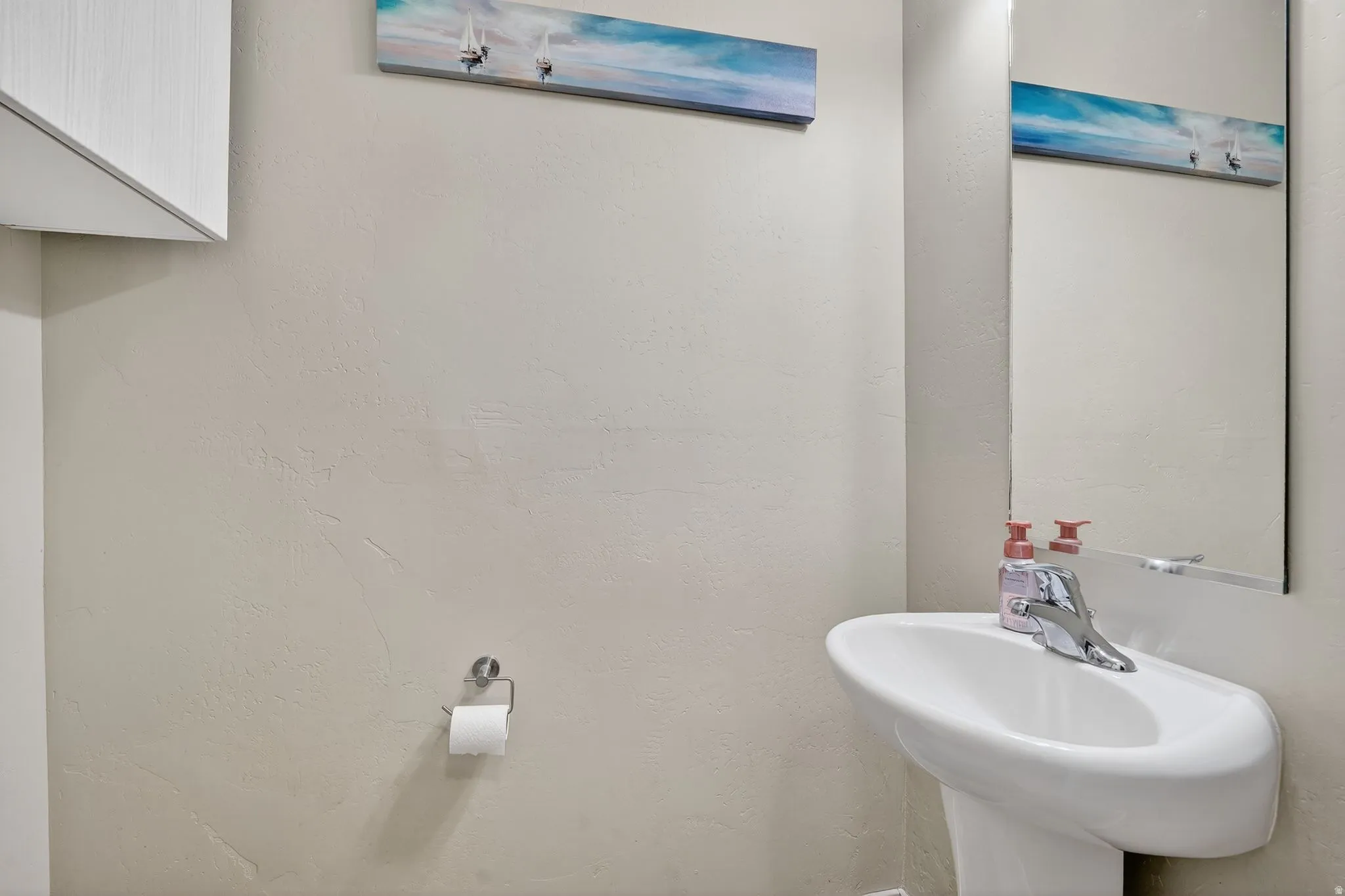 Bathroom featuring a sink and a textured wall