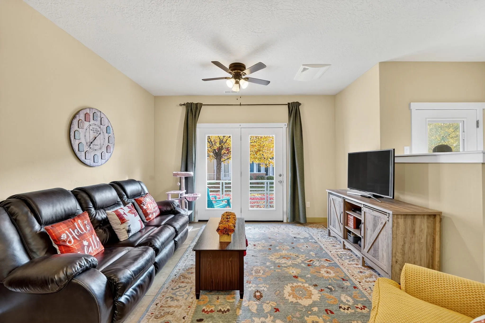 Living area with a textured ceiling and a ceiling fan