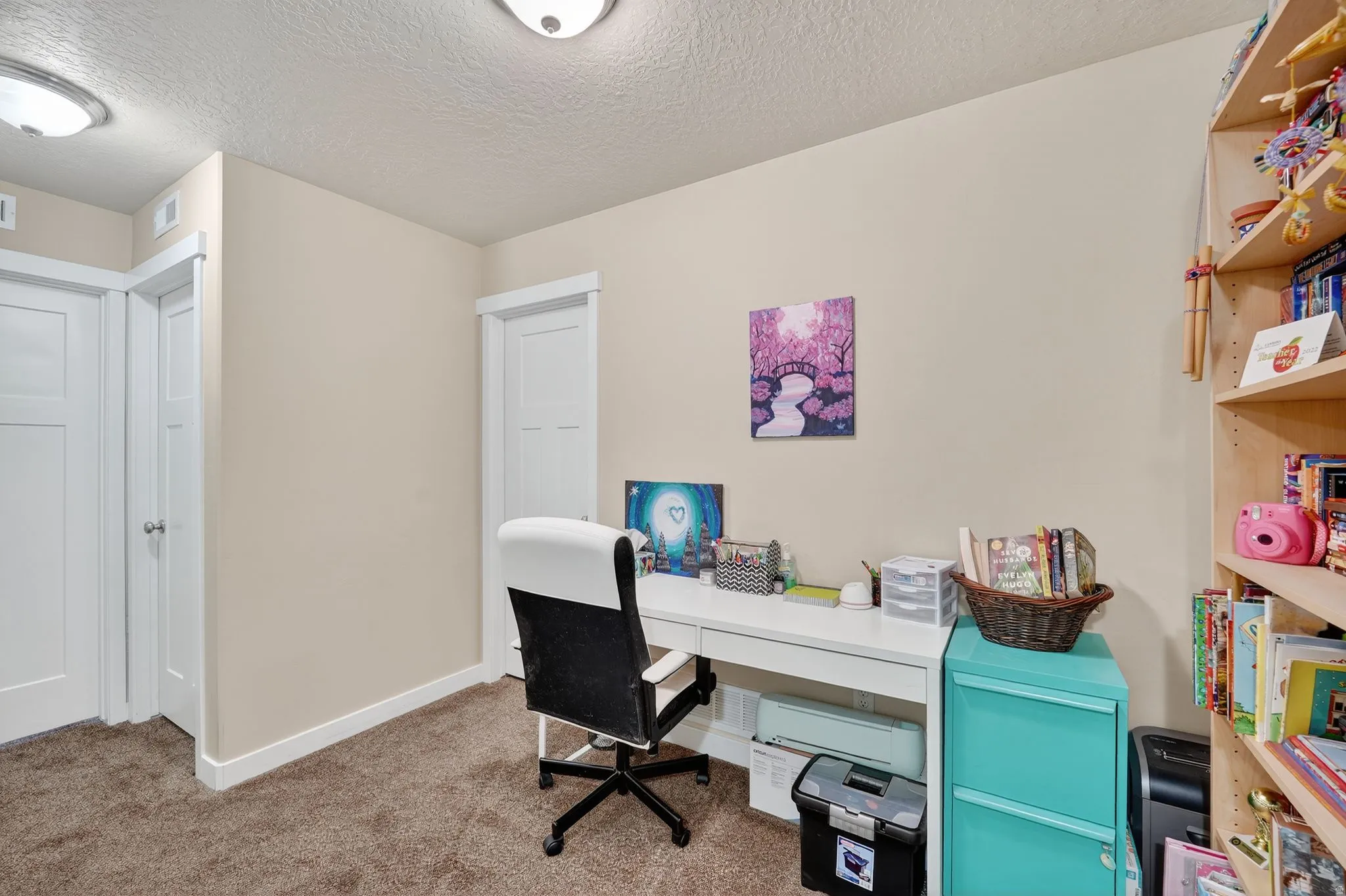 Office area with carpet flooring and a textured ceiling