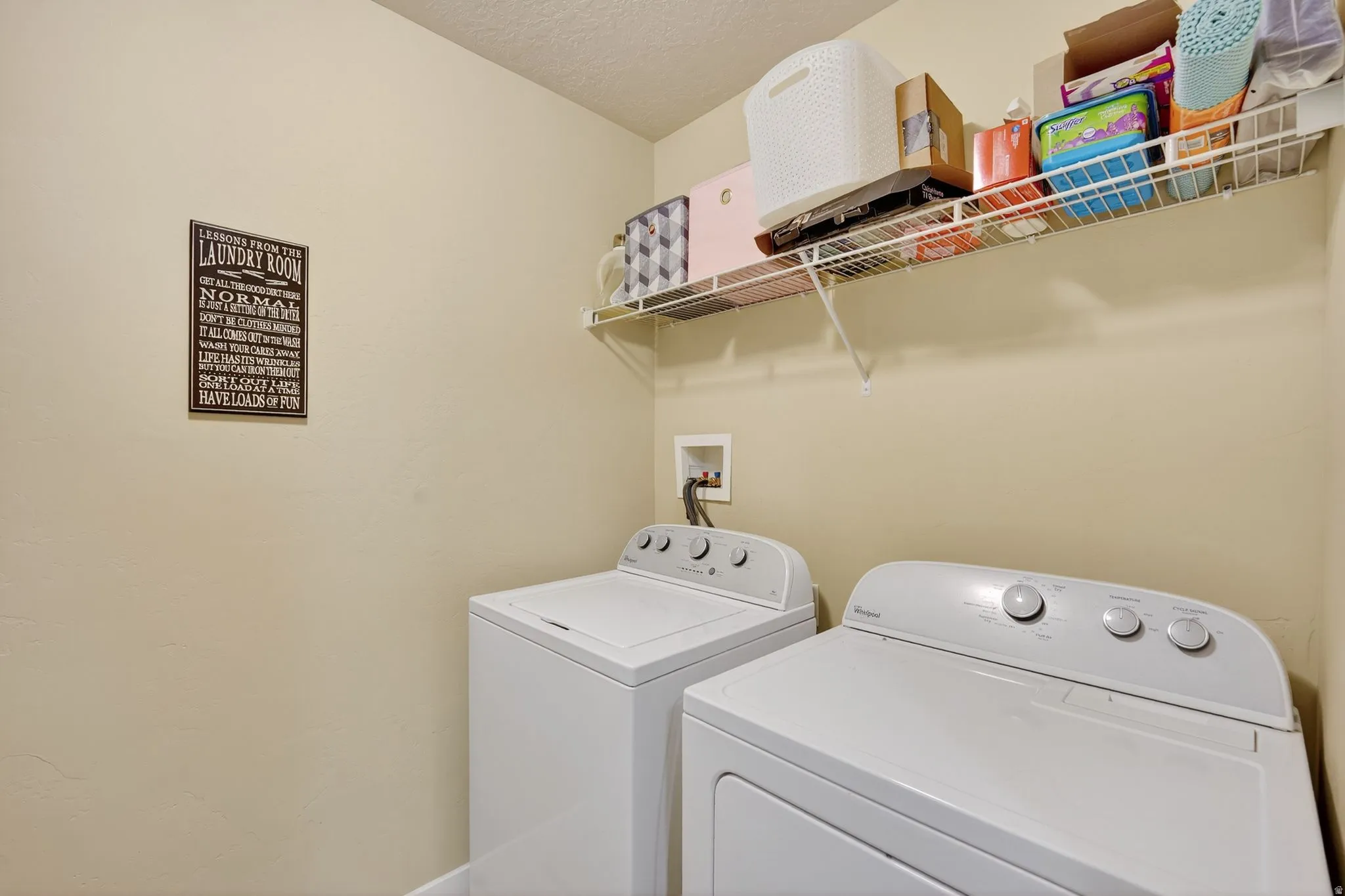 Laundry room featuring washer and dryer and a textured ceiling