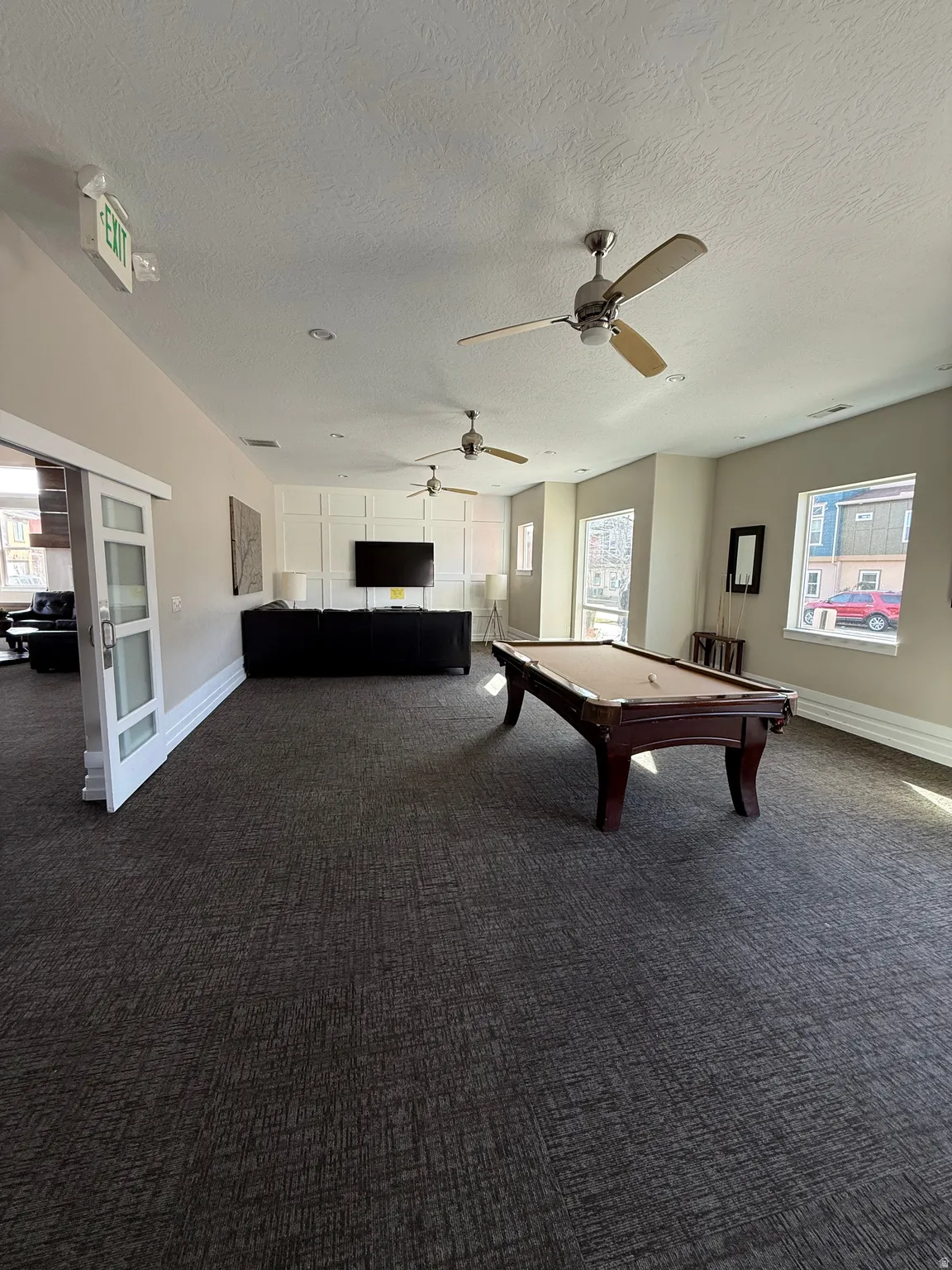 Game room featuring plenty of natural light, billiards, and a textured ceiling