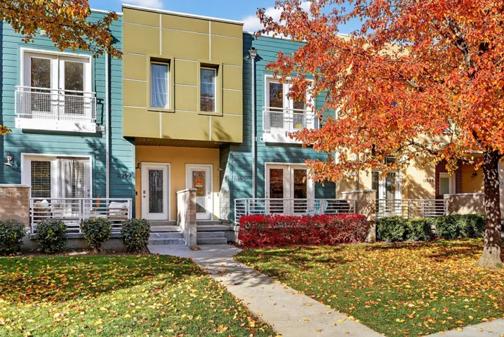View of front of property with a front yard and a balcony