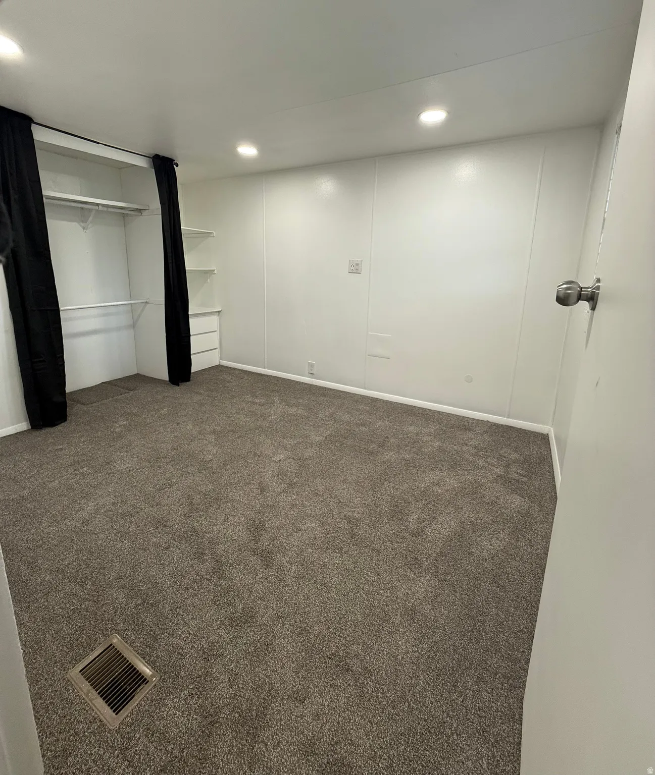 Unfurnished bedroom featuring dark colored carpet, recessed lighting, and a closet