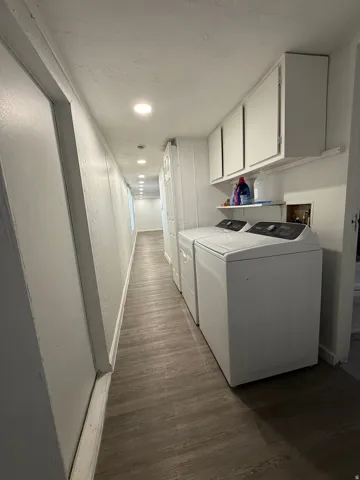 Laundry room featuring dark wood finished floors, cabinet space, independent washer and dryer, and a textured ceiling