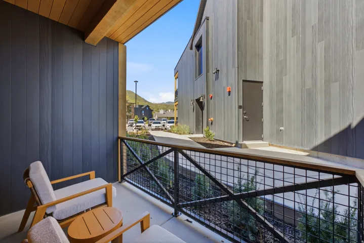 Covered patio with a wood-finish ceiling, concrete flooring, and metal railing