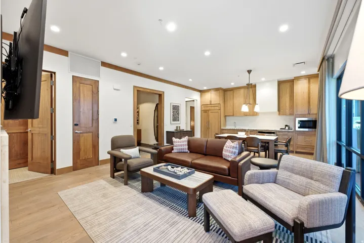Open-concept living area with wood-finish flooring, recessed lighting, and wood trim accents