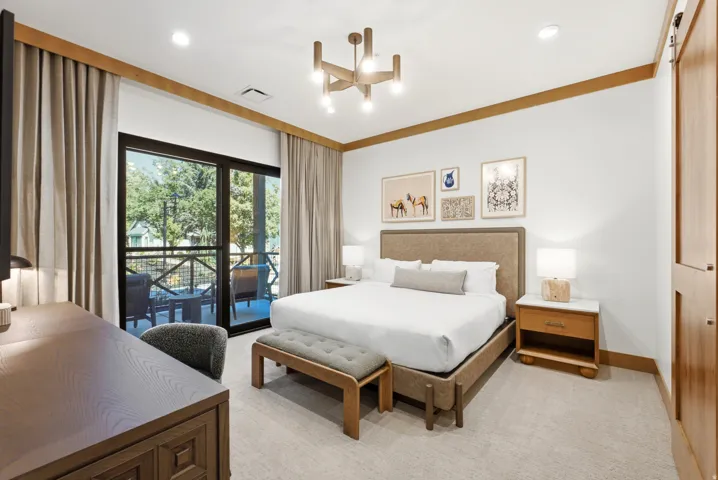 Recessed lighting, wood-finish ceiling trim, and a modern chandelier illuminate this space