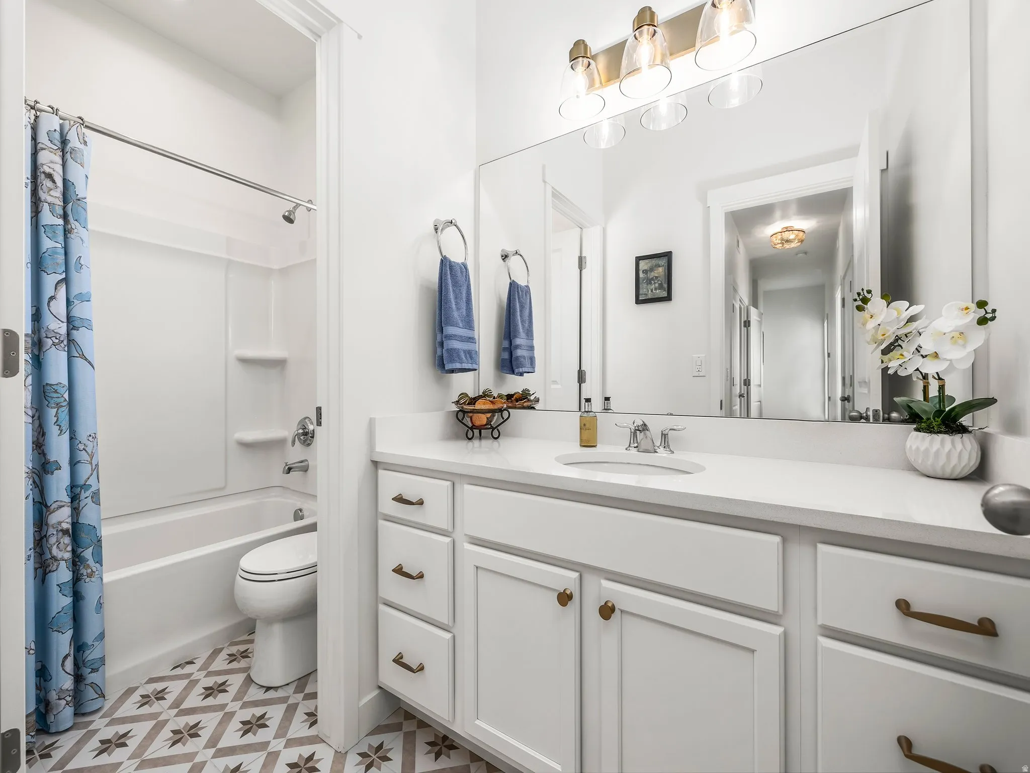 Bathroom featuring vanity and shower / bathtub combination with curtain