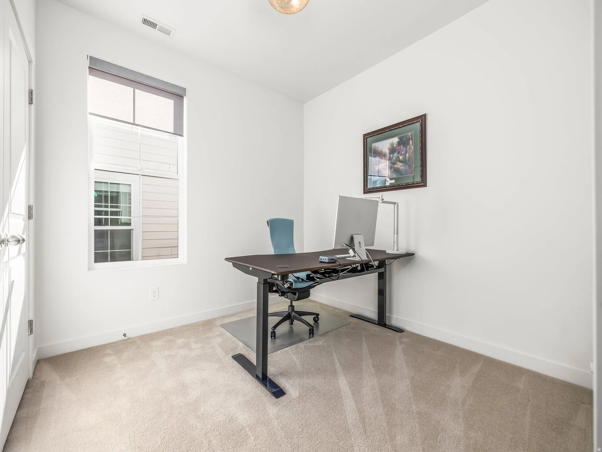 Home office featuring light carpet and baseboards